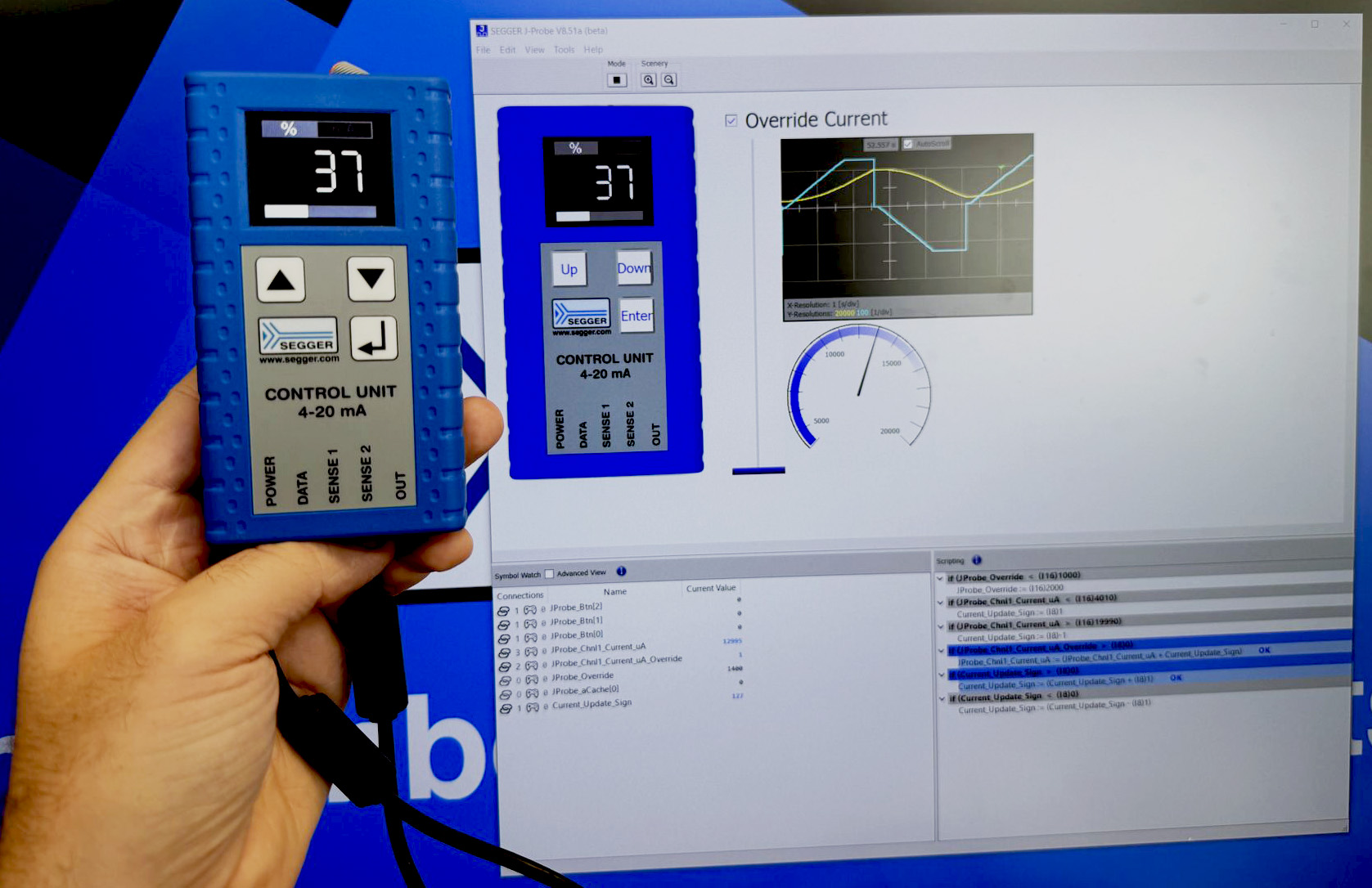 Blue control unit in hand, displaying the number 37 as shown in display uni. on monitor